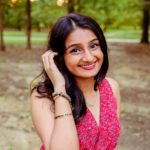 Shivani smiles and tucks her hair behind one ear